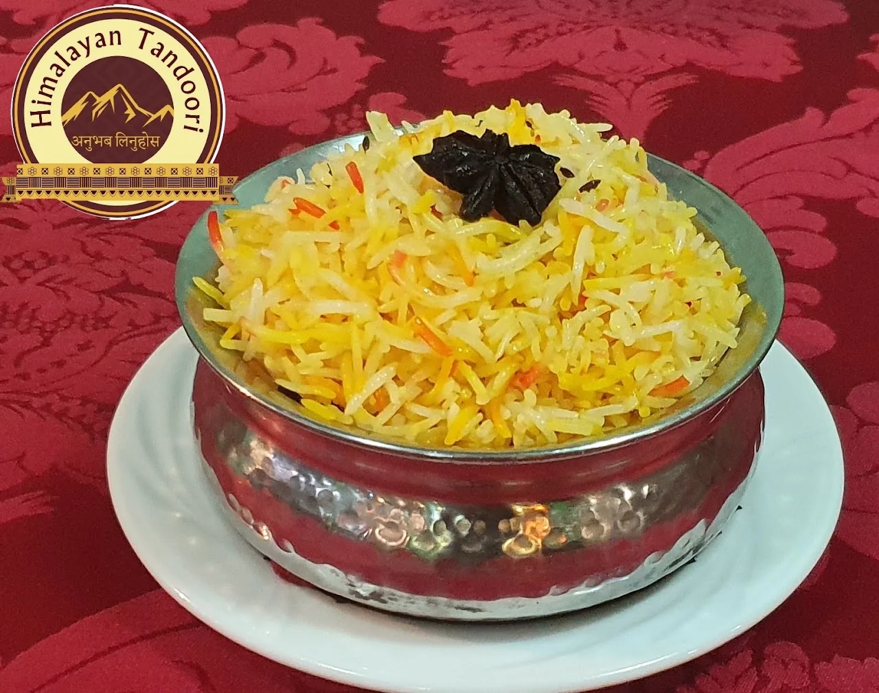 A bowl of yellow rice pilaf garnished with herbs
