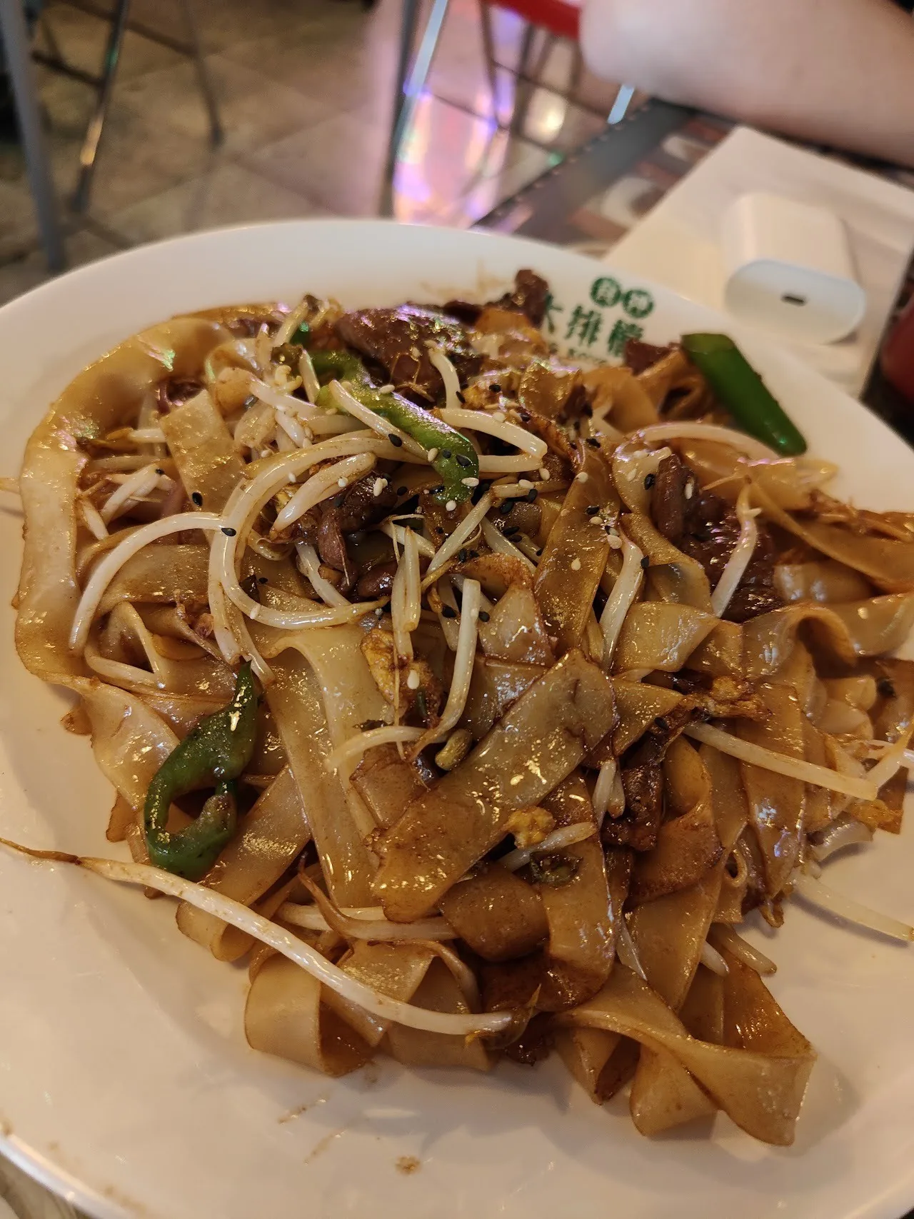 A plate of wide stir-fried rice noodles with bean sprouts