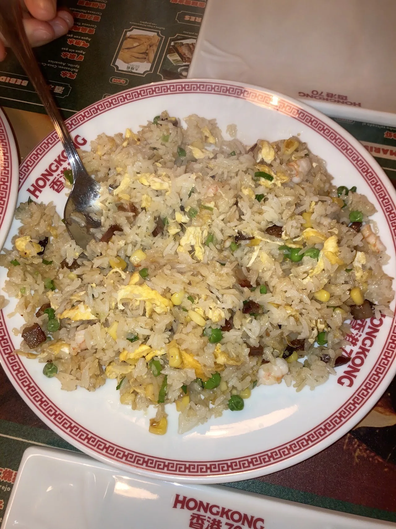 A plate of egg fried rice with a spoon