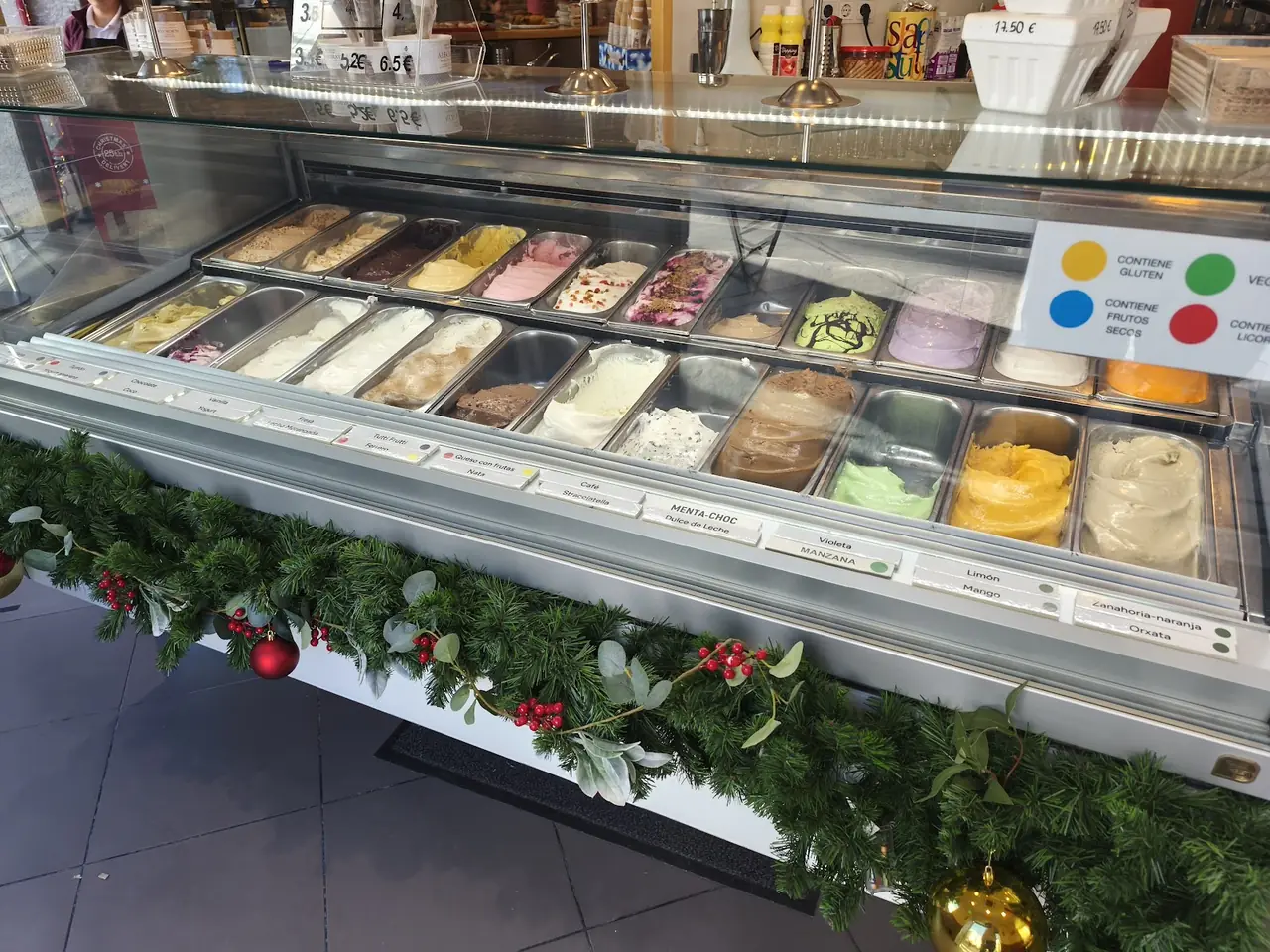 Gelato display case with rows of flavors including orxata, limon, mango and chocolate