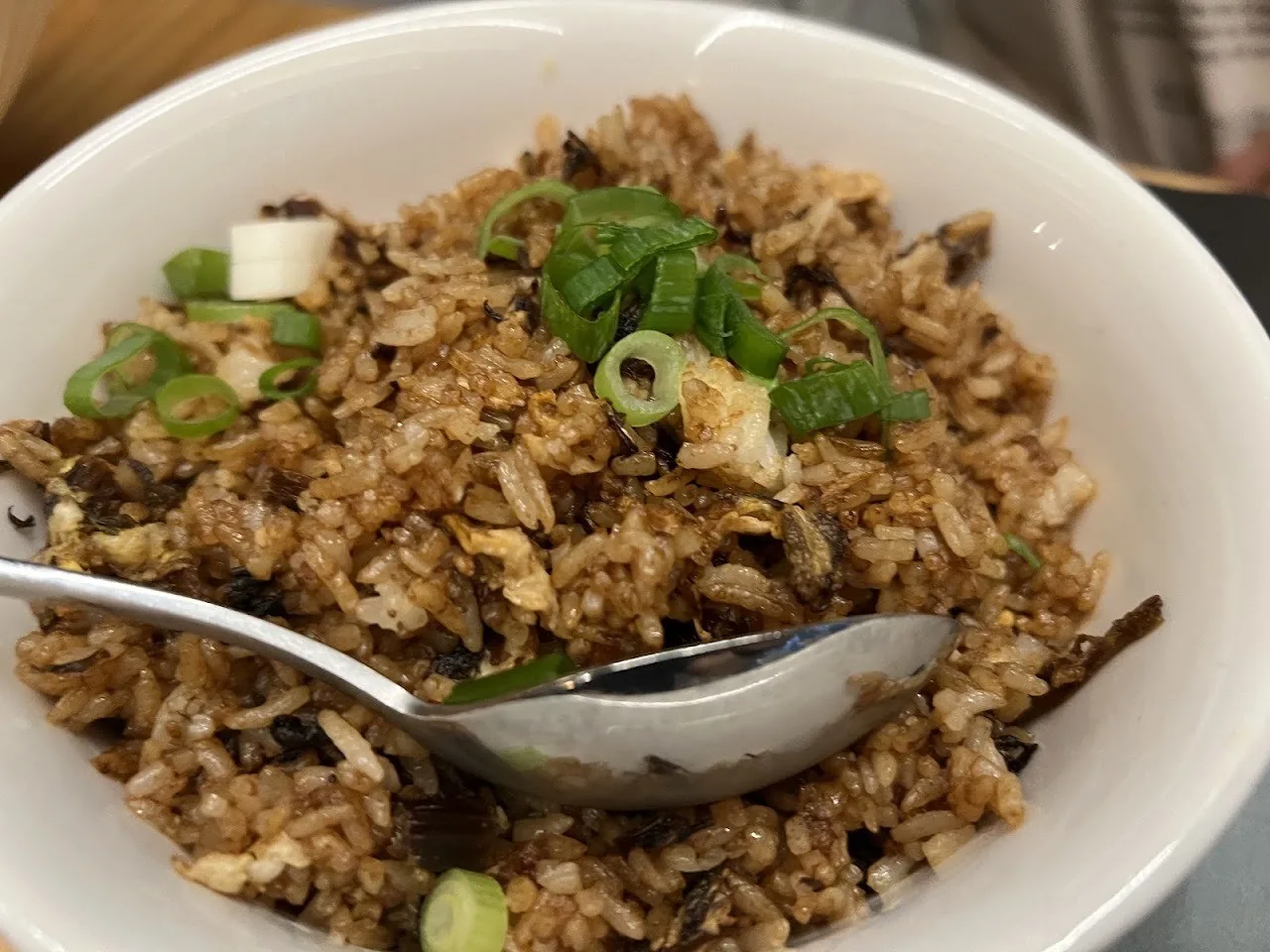 A bowl of fried rice with a spoon
