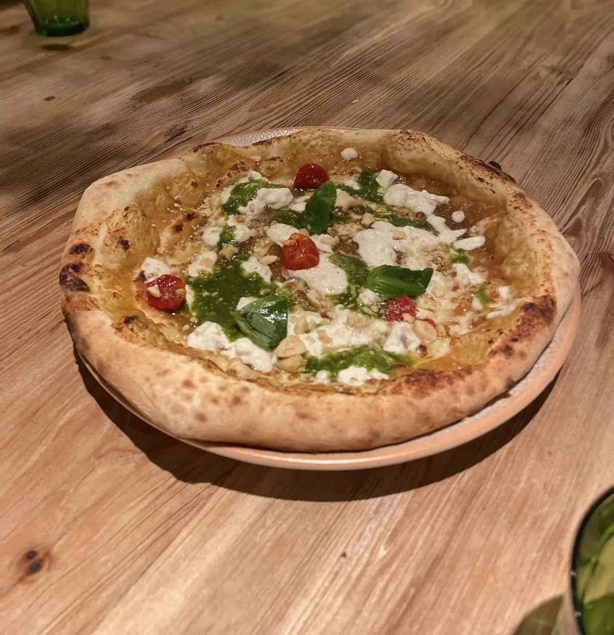 A wood-fired pizza topped with prosciutto and arugula.