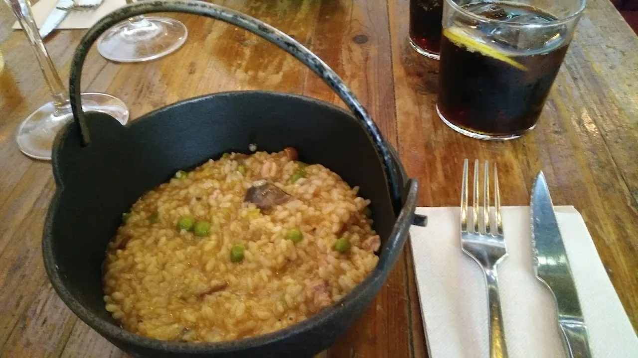 A pot of creamy rice risotto with dark broth