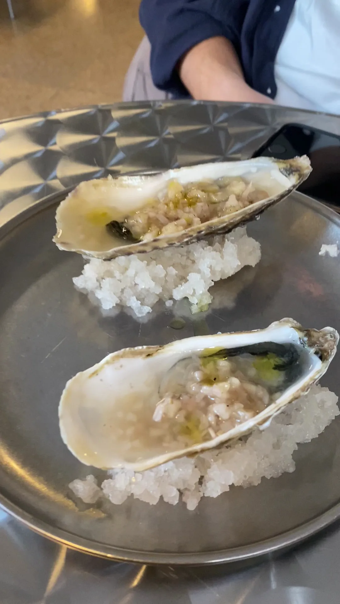 Two oysters on the half shell served over a bed of rice