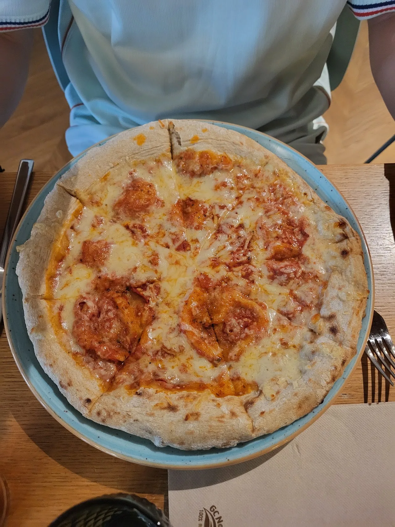 An overhead view of a round pizza with melted cheese