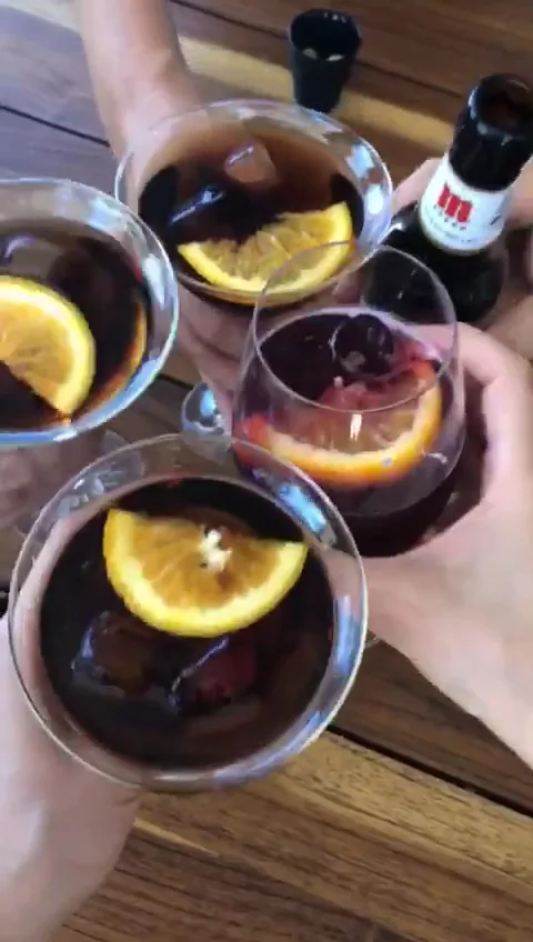 Three cocktails garnished with lemon wheels held up together