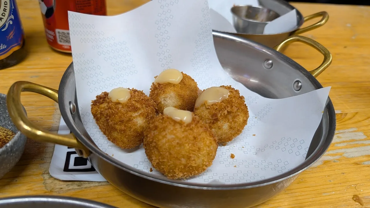 Fried golden croquettes in a metal dish lined with paper