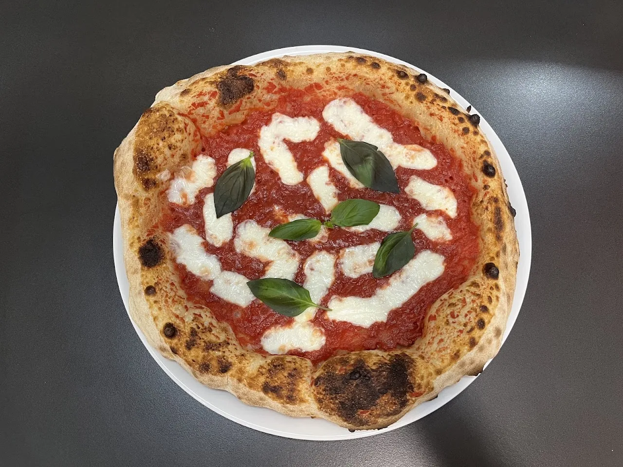 A margherita pizza with fresh basil leaves