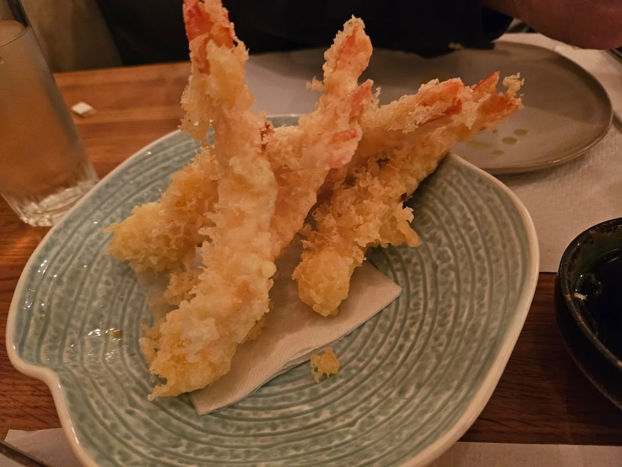 Three tempura prawns on a green plate