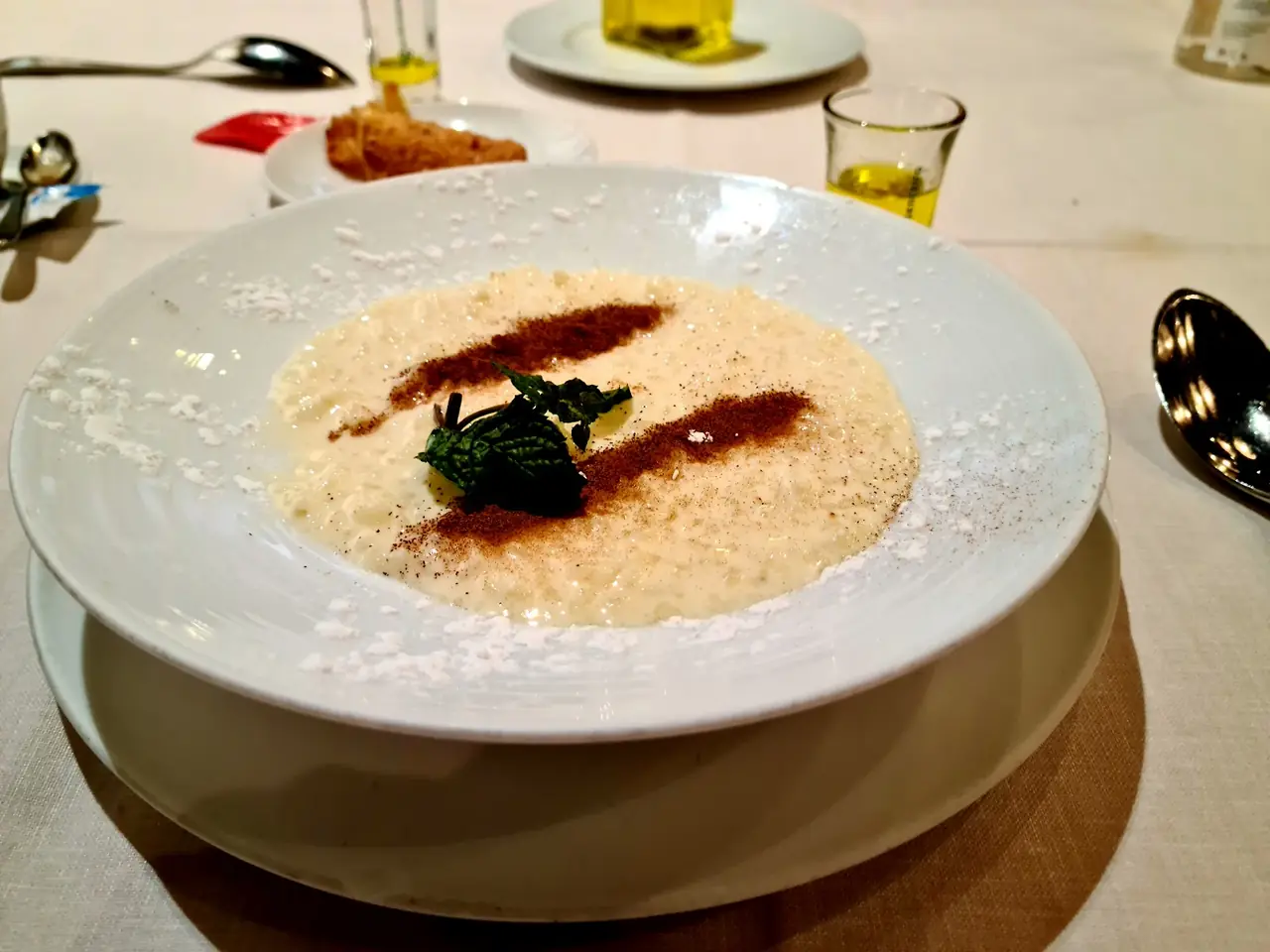 Creamy rice pudding dessert dusted with cinnamon and powdered sugar, garnished with mint