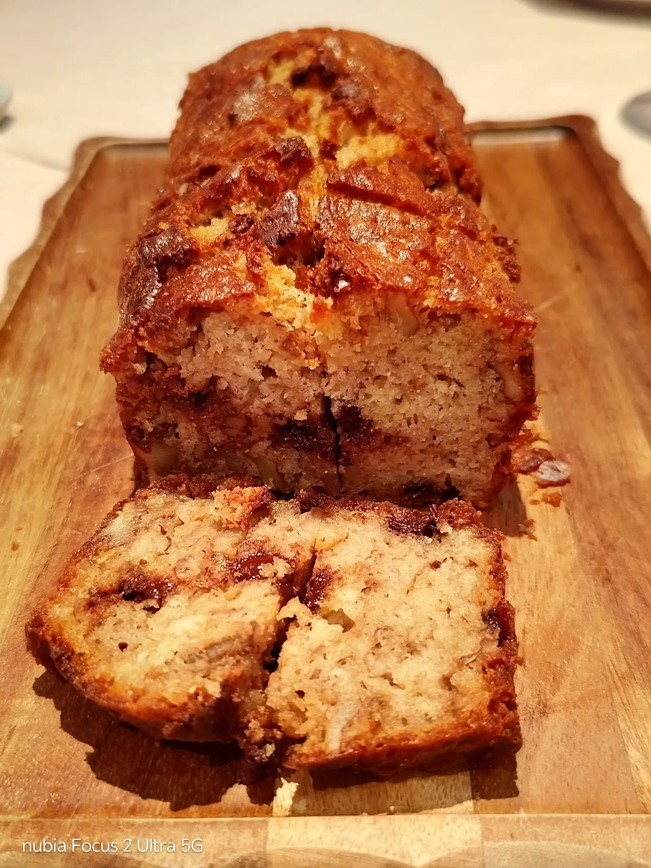 A sliced loaf of banana bread on a wooden board