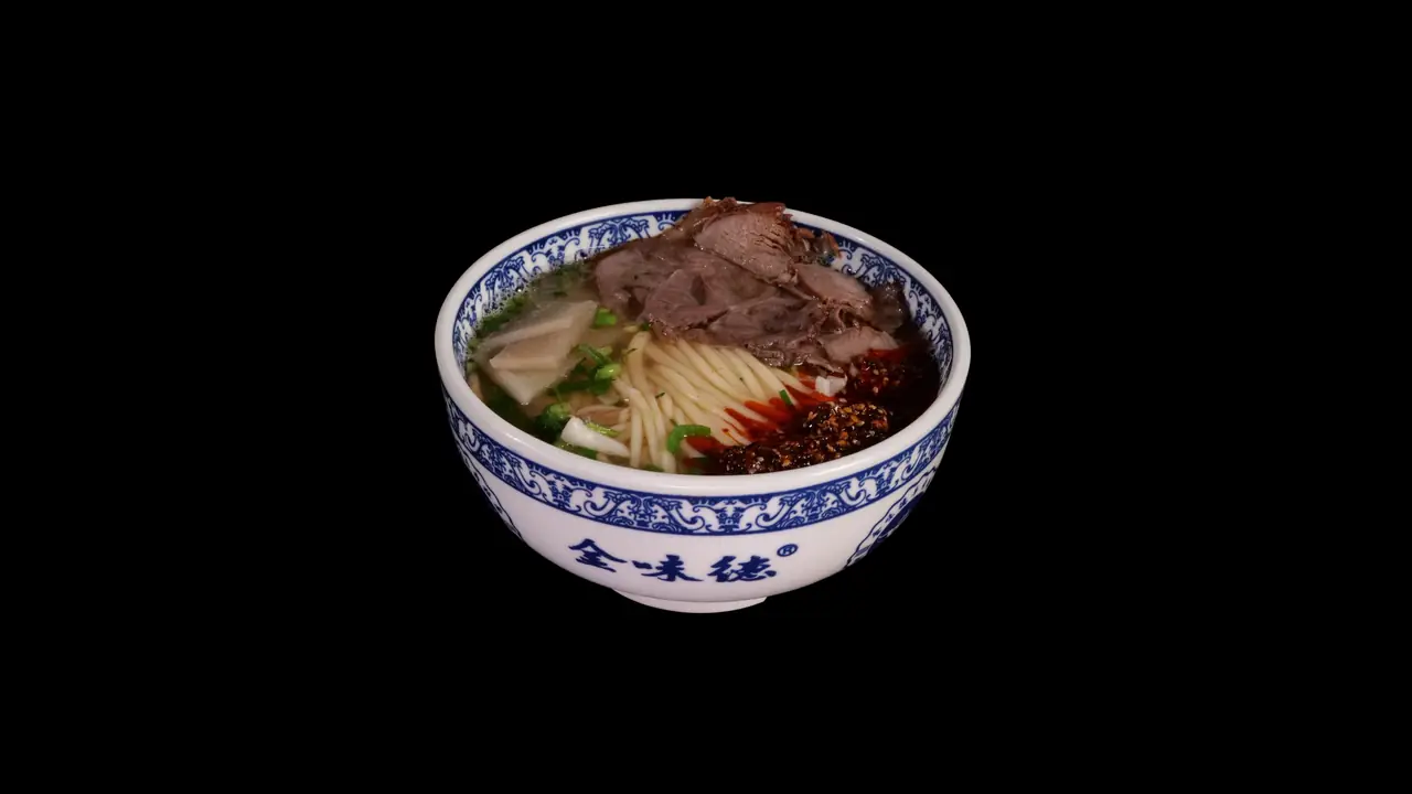 Blue-and-white patterned bowl of Lanzhou beef noodle soup with sliced beef, thin hand-pulled noodles, scallions, radish, and chili oil in clear broth, Jin Da Le