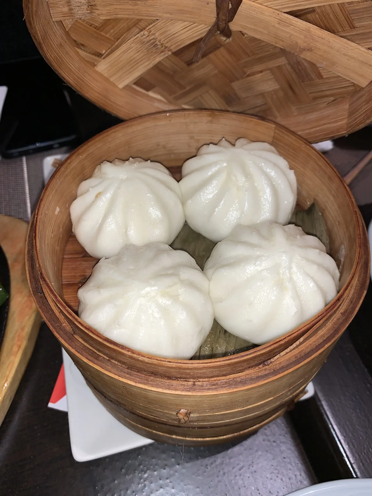A bamboo steamer basket of steamed buns