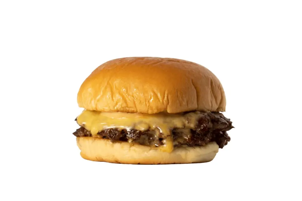 Smashed cheeseburger with melted cheese on a glossy bun, isolated on white