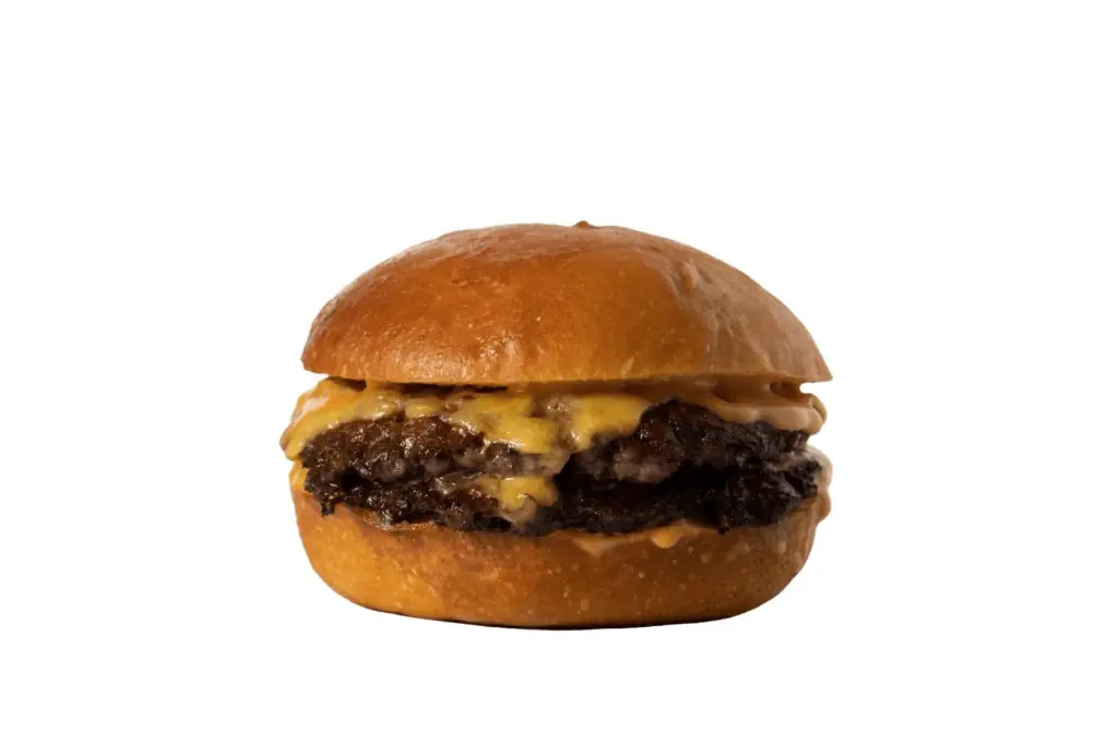 Double smashed cheeseburger with sauce on a bun, isolated on white