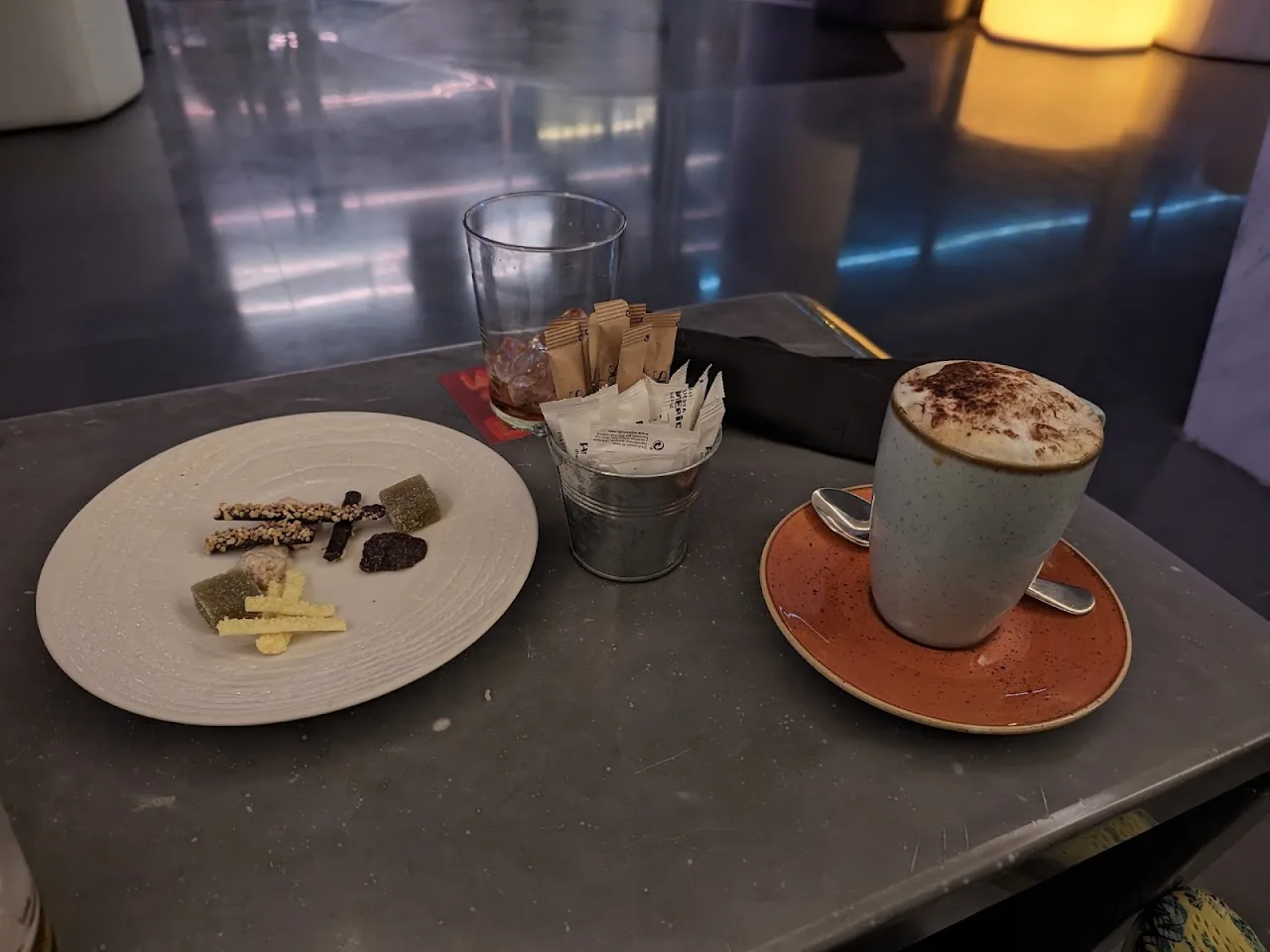 Two small desserts on a table beside two coffees