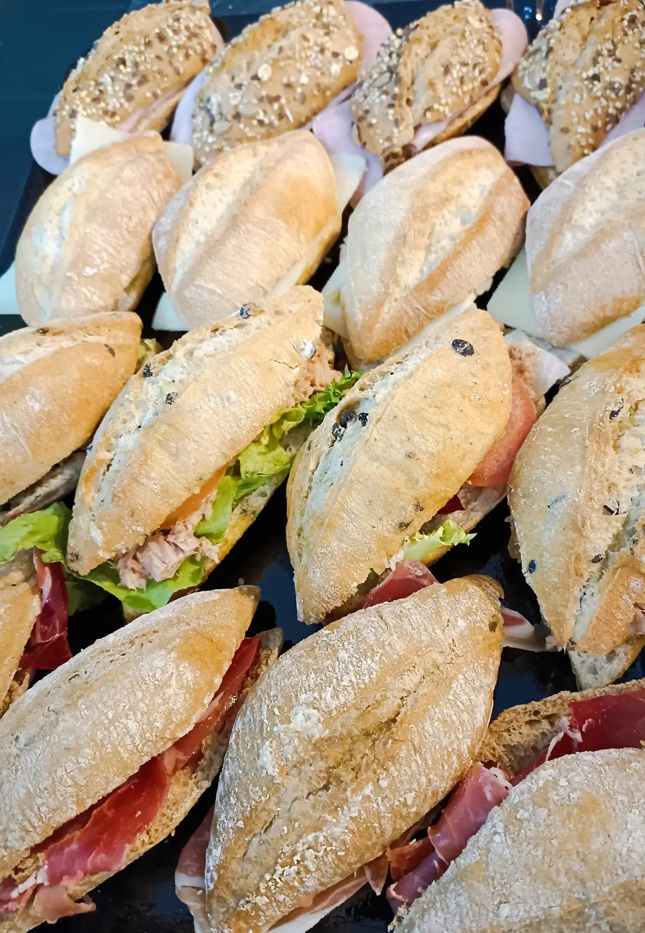 Tray of assorted filled bread rolls with ham, cheese, tuna and lettuce, and cured meat, Kata