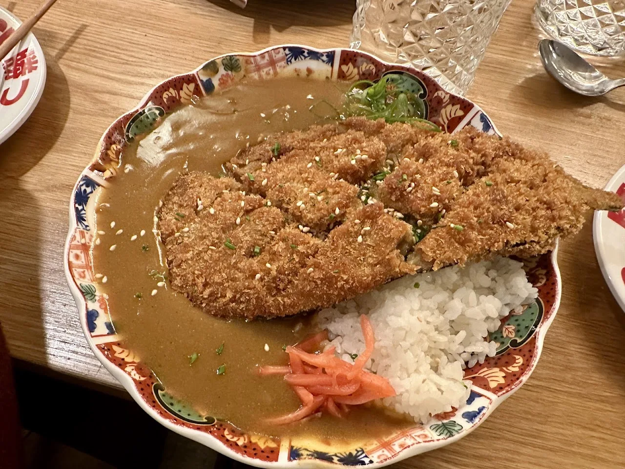 A crispy pork katsu cutlet over rice with curry sauce