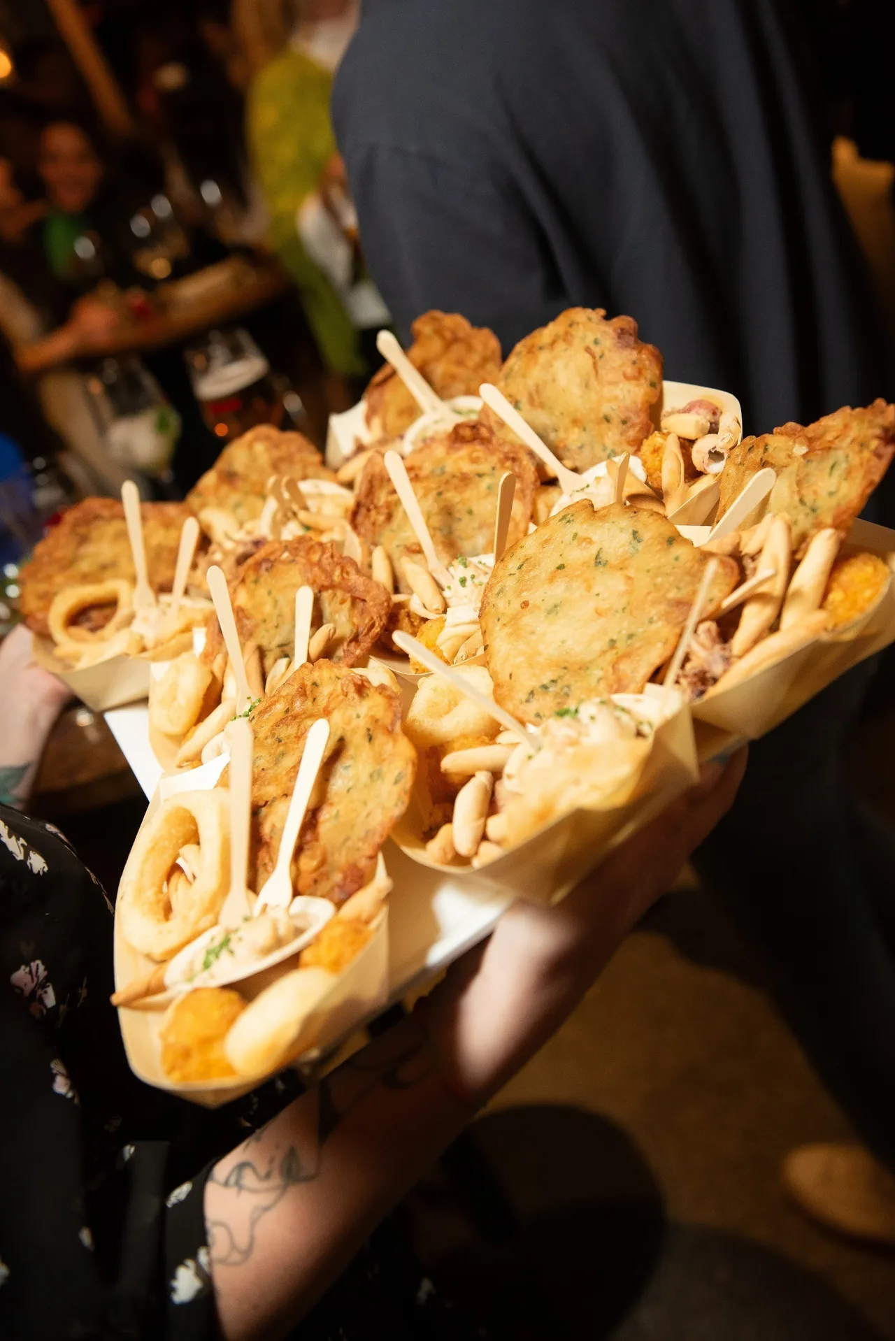 A wooden serving tray of fried pieces in paper cones