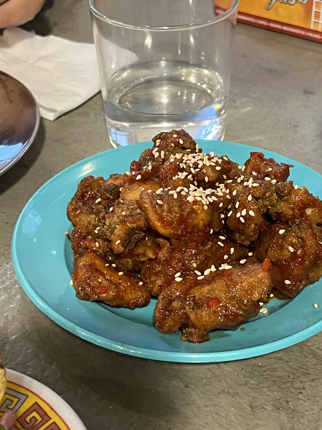 Sesame-crusted fried chicken wings on a blue plate
