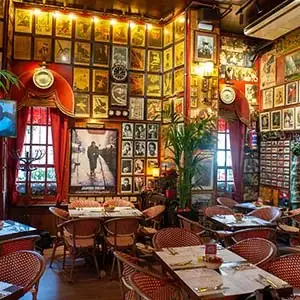 Pub dining room walls covered in framed photos and memorabilia above rows of bistro tables and chairs