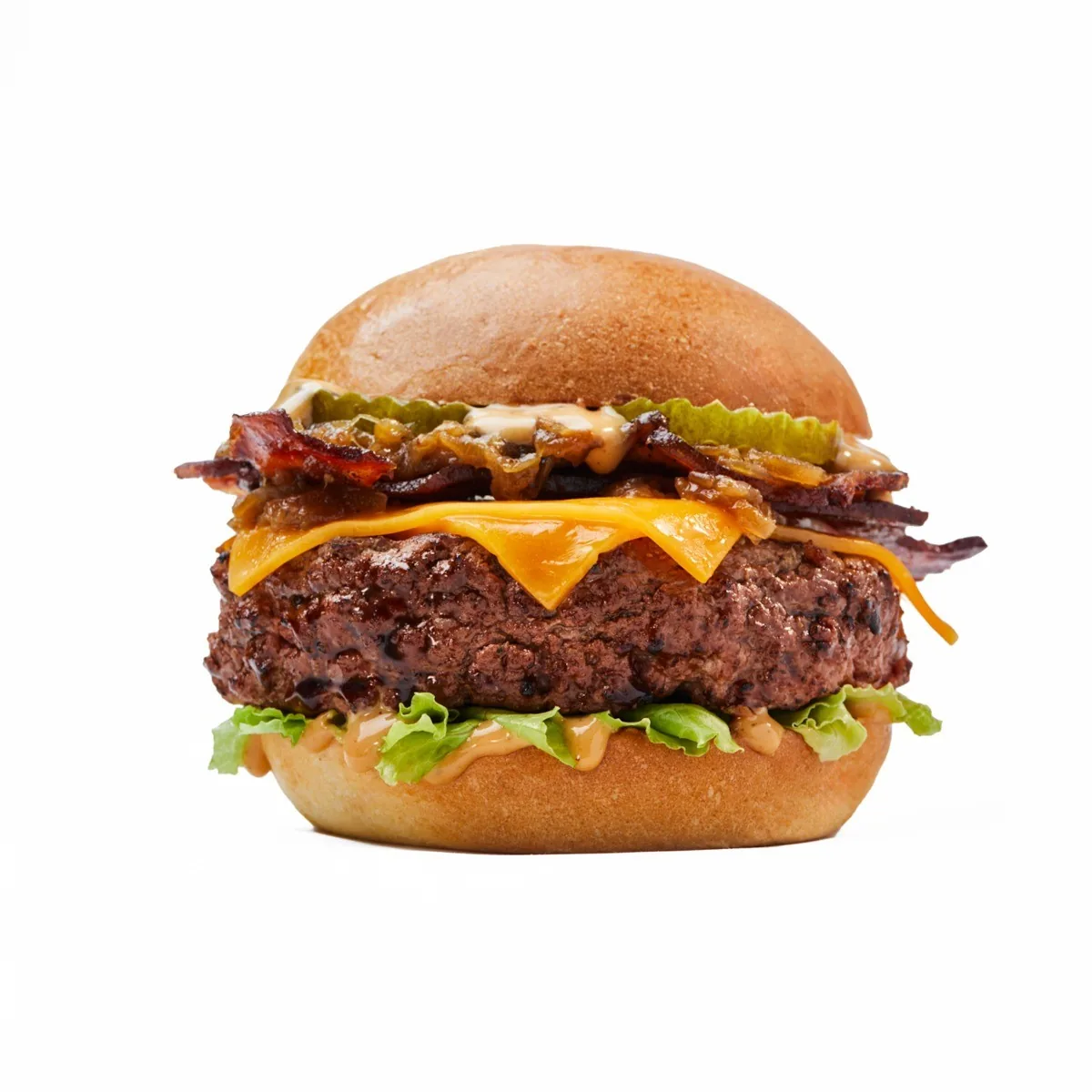 A tall burger with bacon, cheese, pickles and a glossy bun on a white background