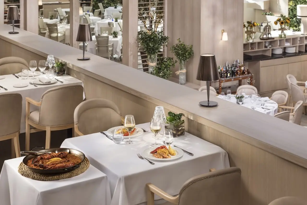 A row of table settings in an elegant white dining room.
