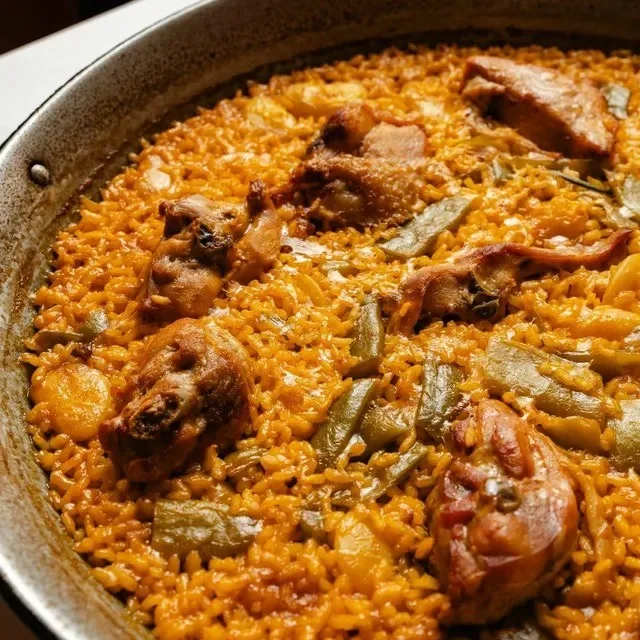 Close-up of paella valenciana with chicken and flat green beans