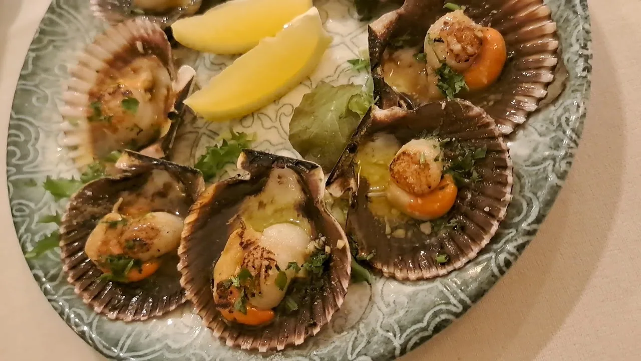 Grilled scallops served in their shells with a lemon wedge