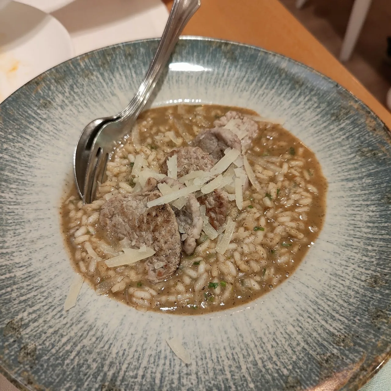 A bowl of risotto garnished with herbs and grated cheese