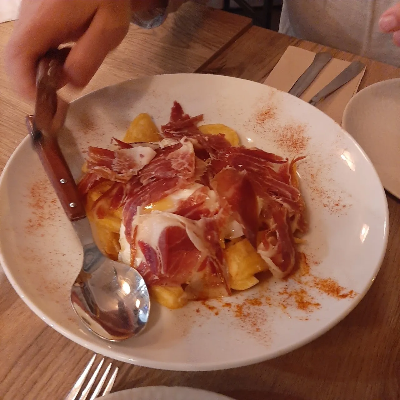 A plate of cured ham served with a spoon