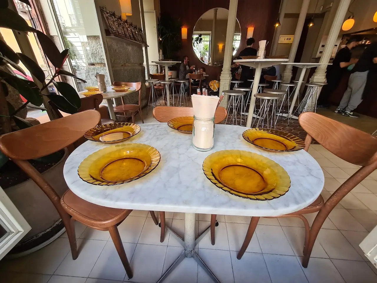 Marble-topped dining table set with amber glass plates in the dining room