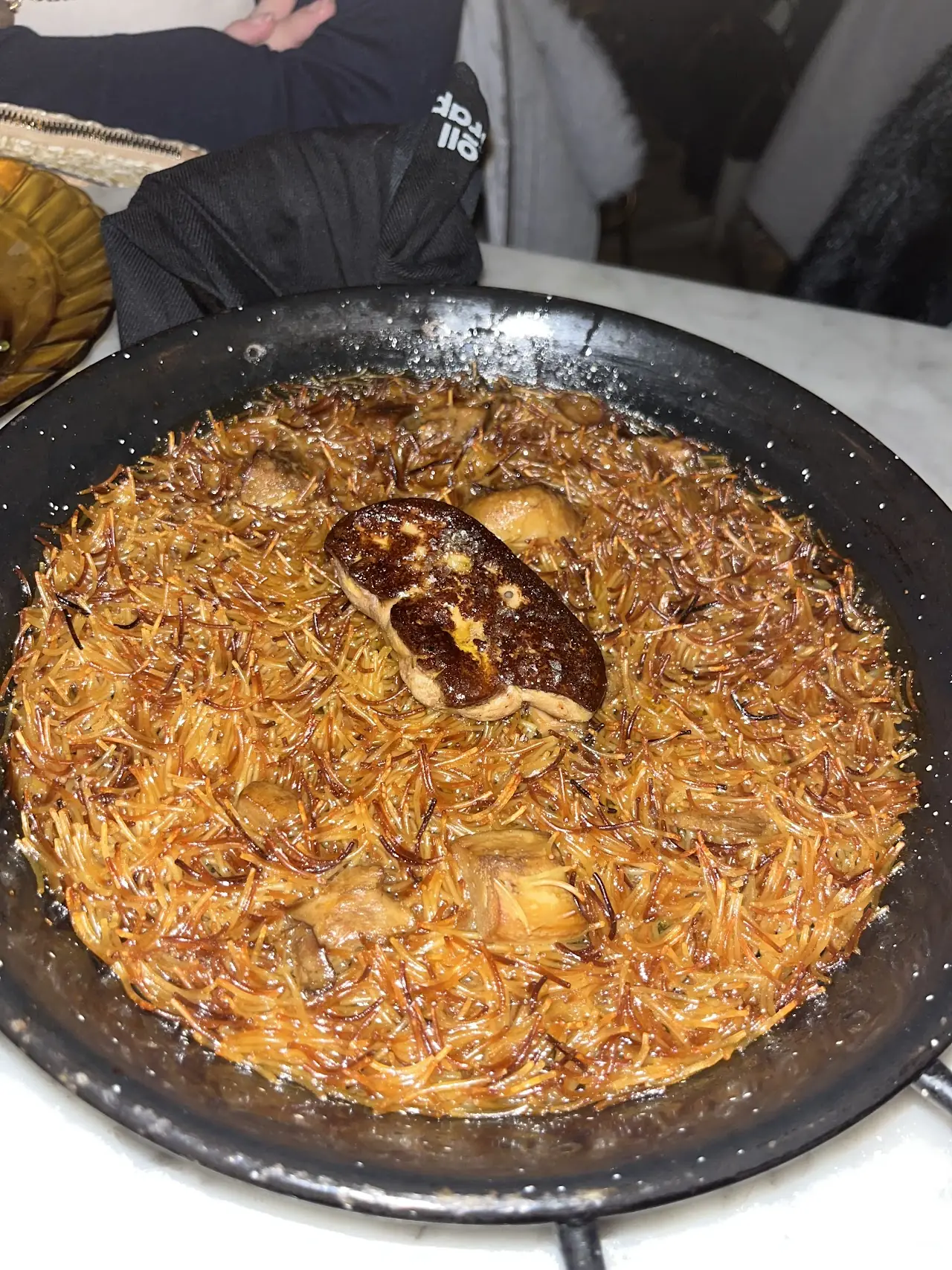 Paella-style rice dish with seafood in a black pan