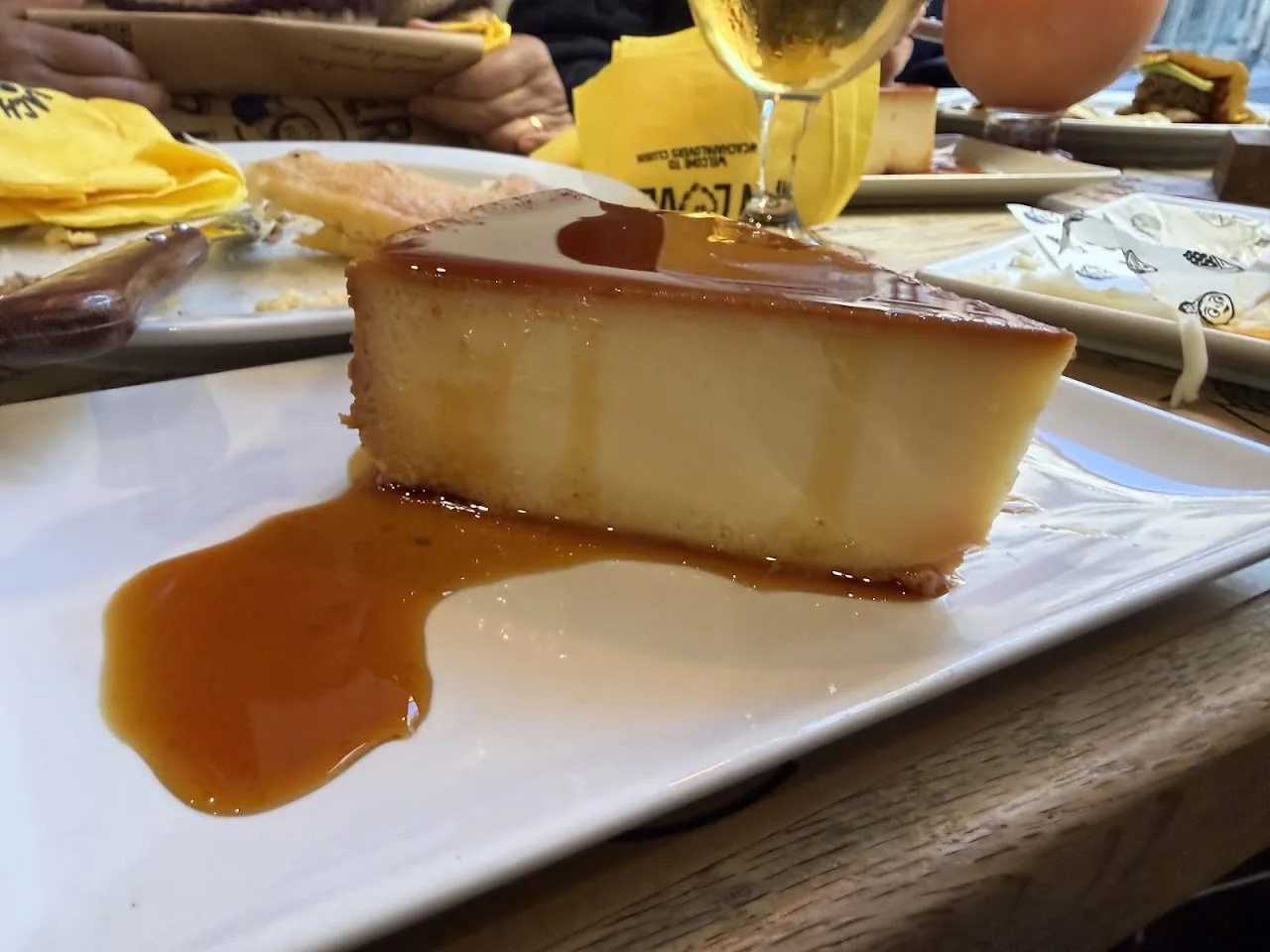 A slice of flan dessert drizzled with caramel sauce