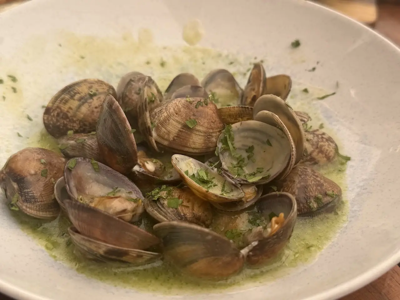 Clams in a garlic and parsley white wine sauce on a plate
