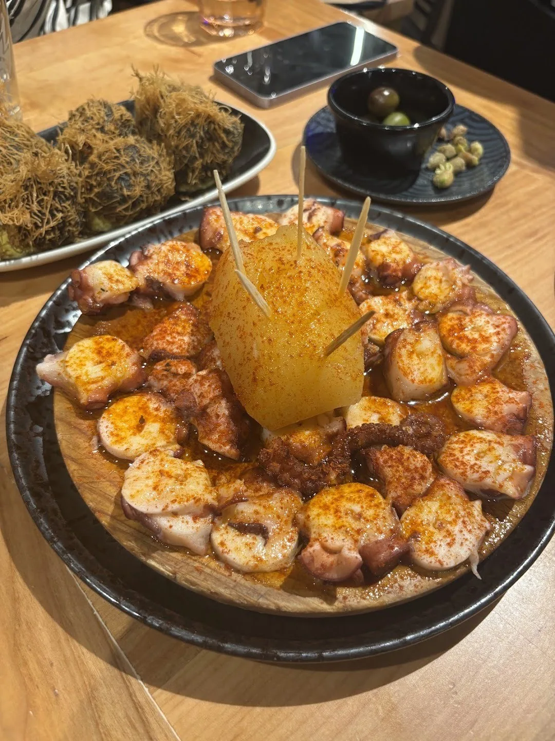 A round dish of golden cooked seafood pieces around a pale centre