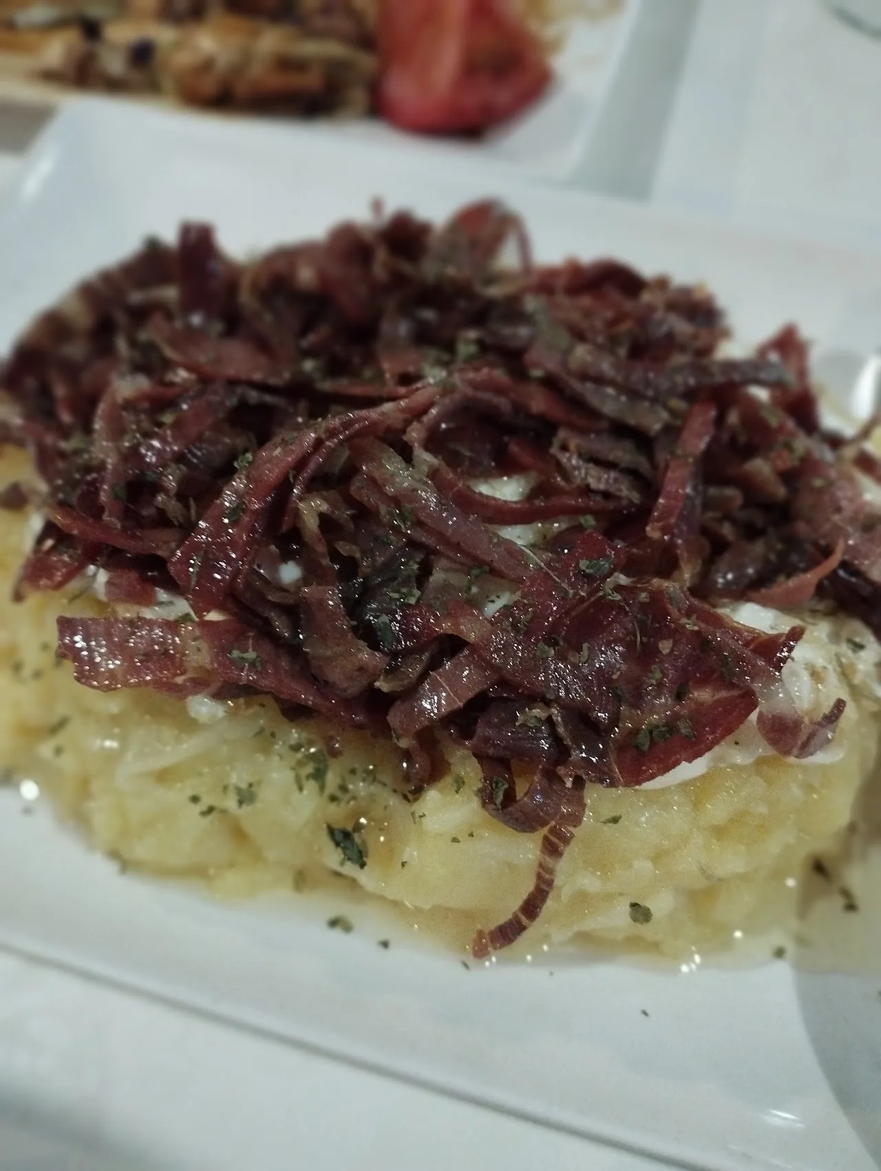 Shredded cured ham piled on a bed of mashed potato