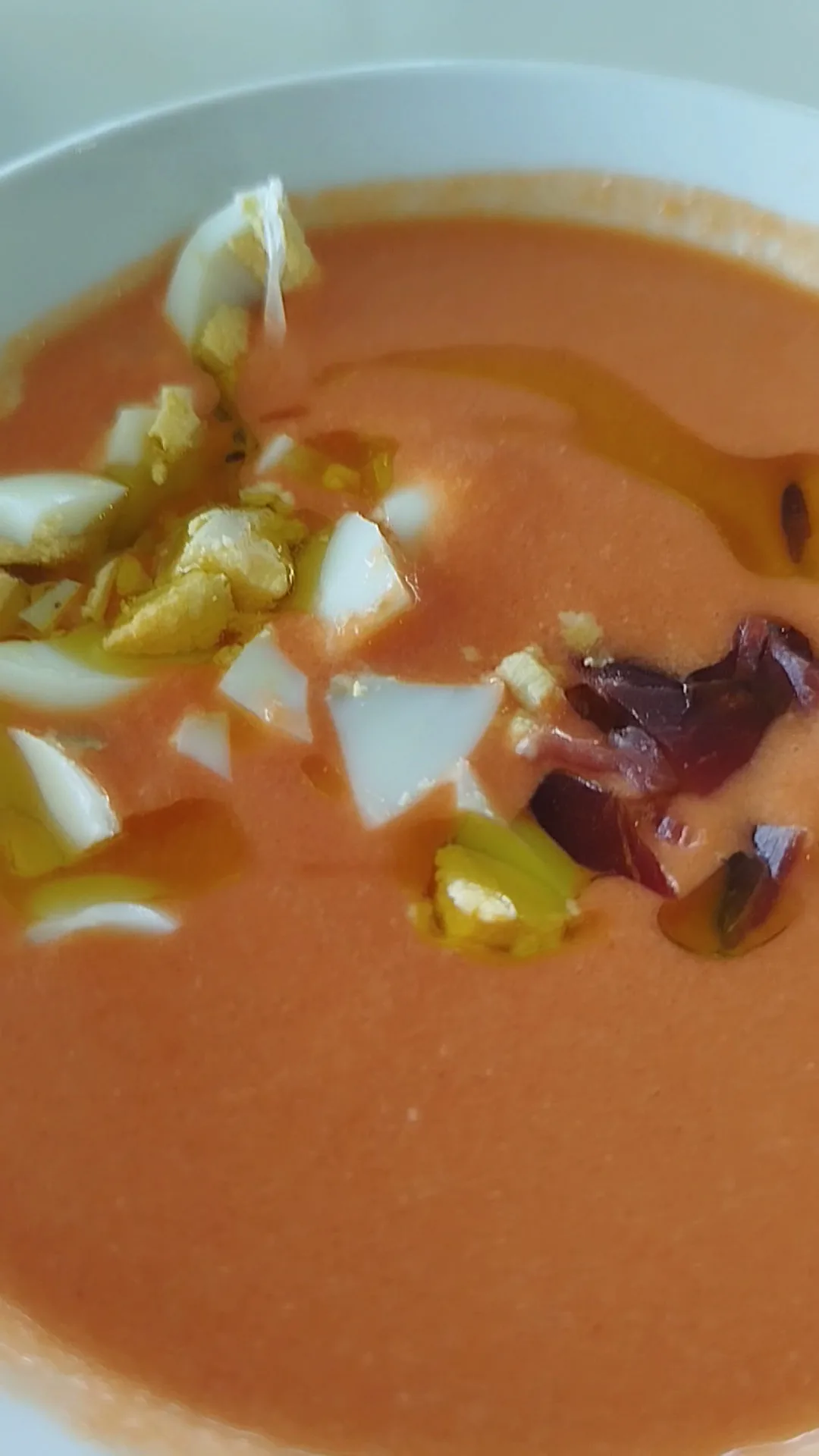 A bowl of gazpacho soup garnished with chopped vegetables