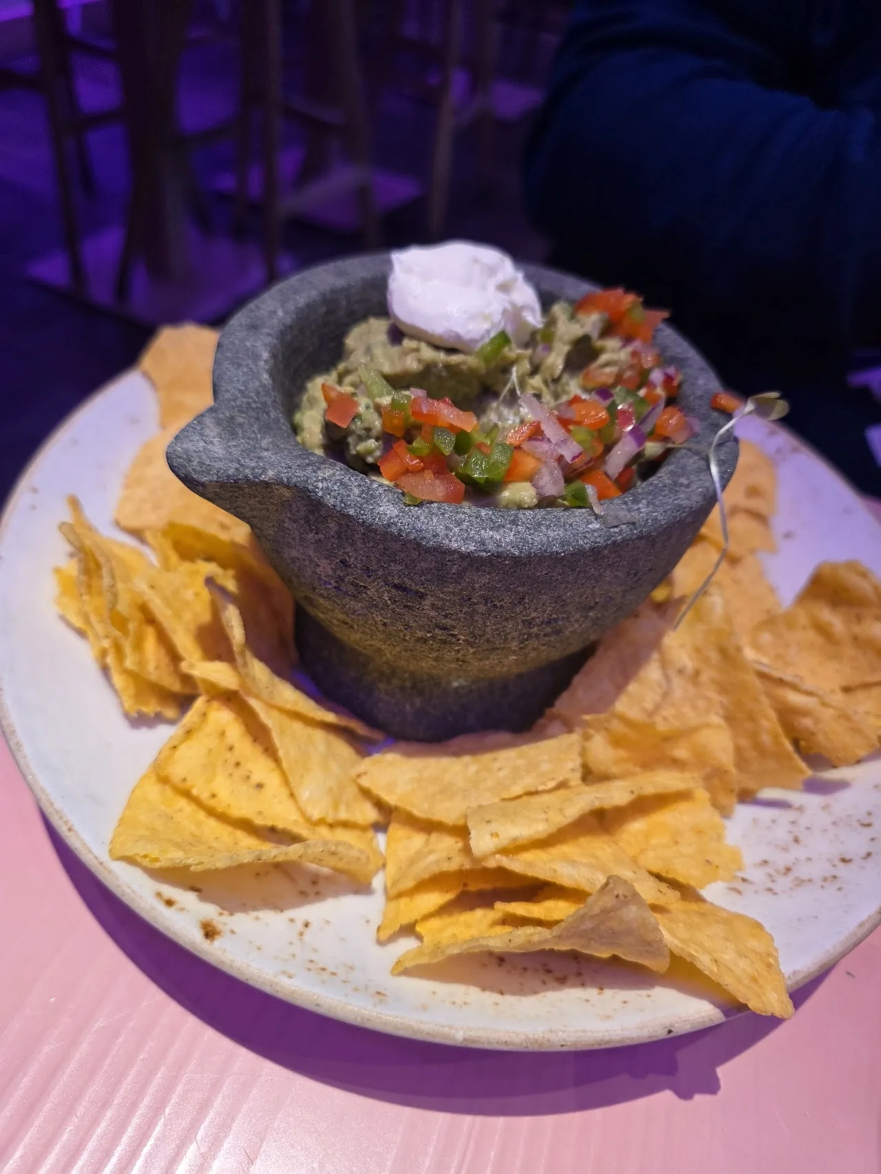 Guacamole served in a stone mortar with tortilla chips