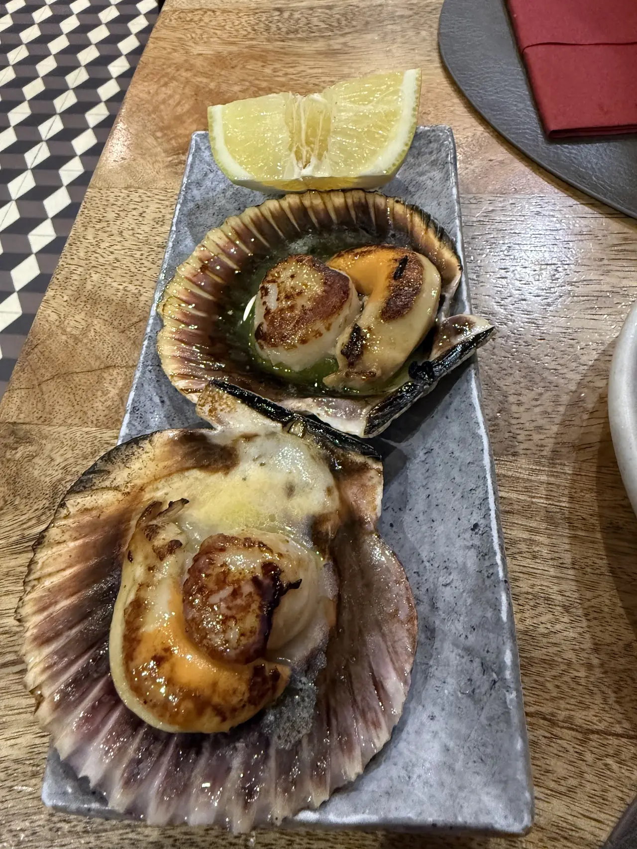 Two scallops gratinated in their shells, served with a lemon wedge