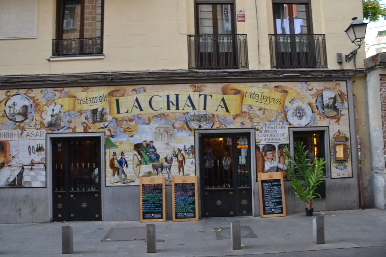 Daytime exterior of La Chata's tiled facade at Cava Baja 24, wider angle showing the full building above the restaurant.