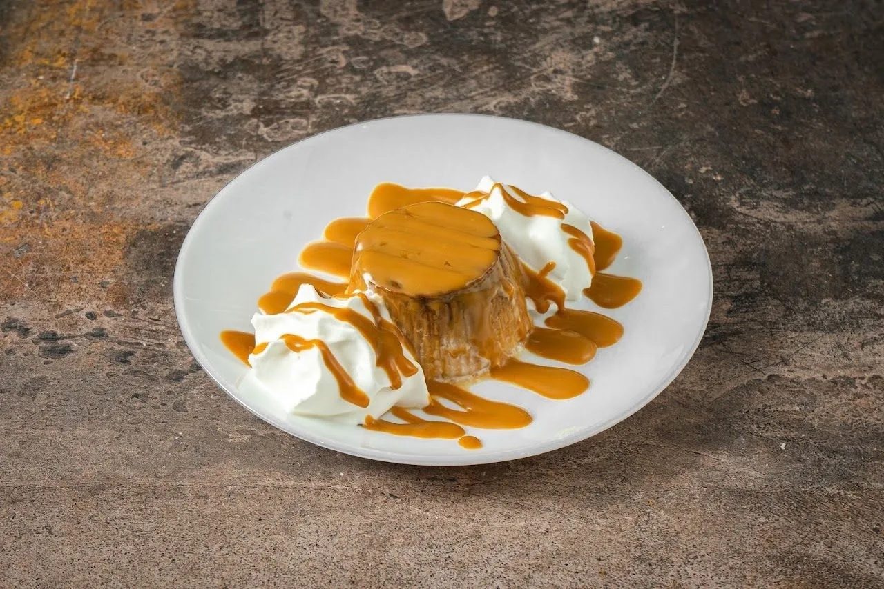 A dessert with caramel sauce and whipped cream on a white plate