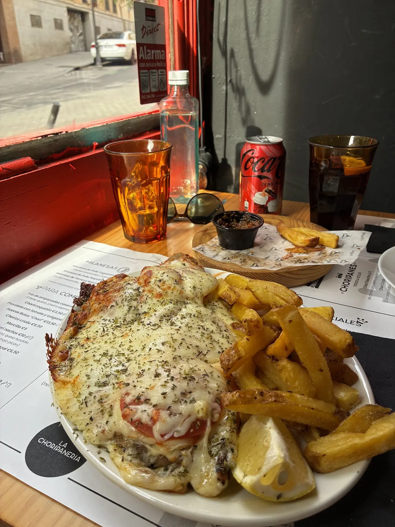 Milanesa napolitana topped with melted cheese and tomato, with chips.