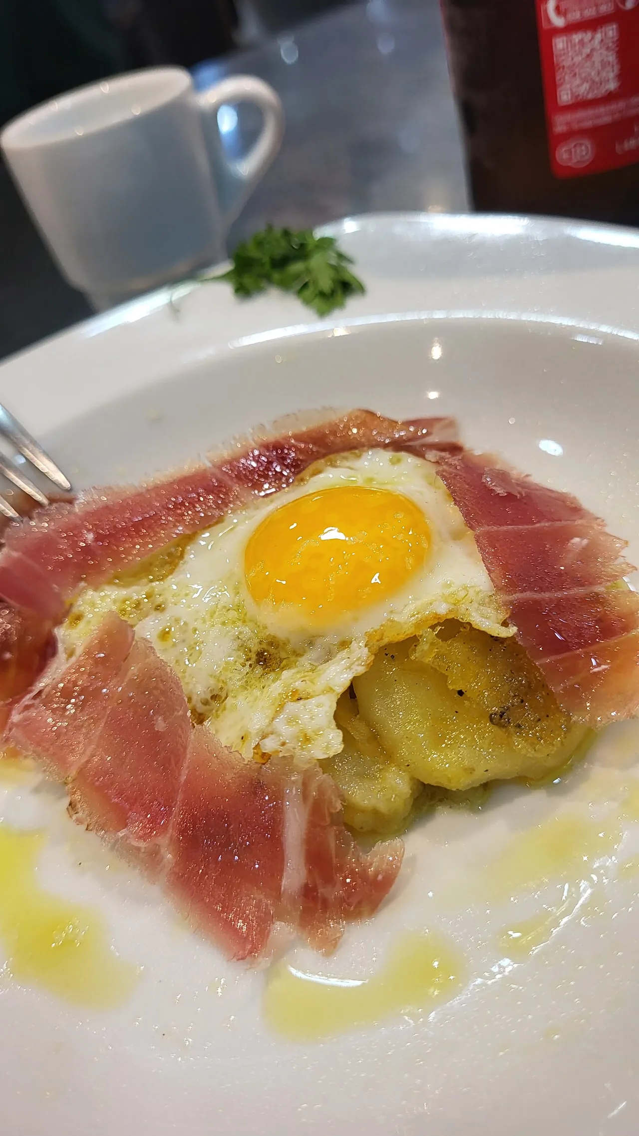 A fried egg over ham and potatoes