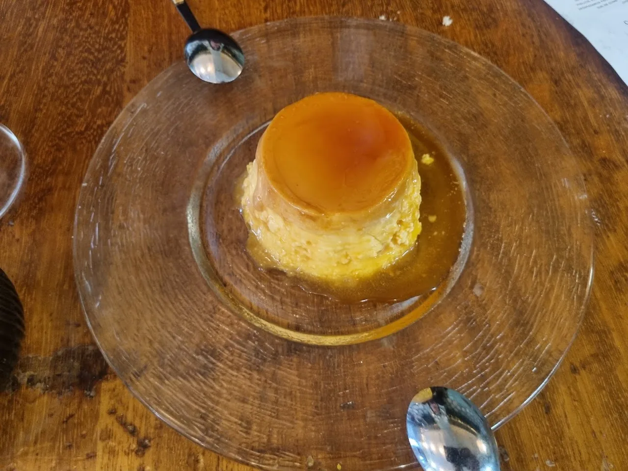 A caramel flan on a glass plate