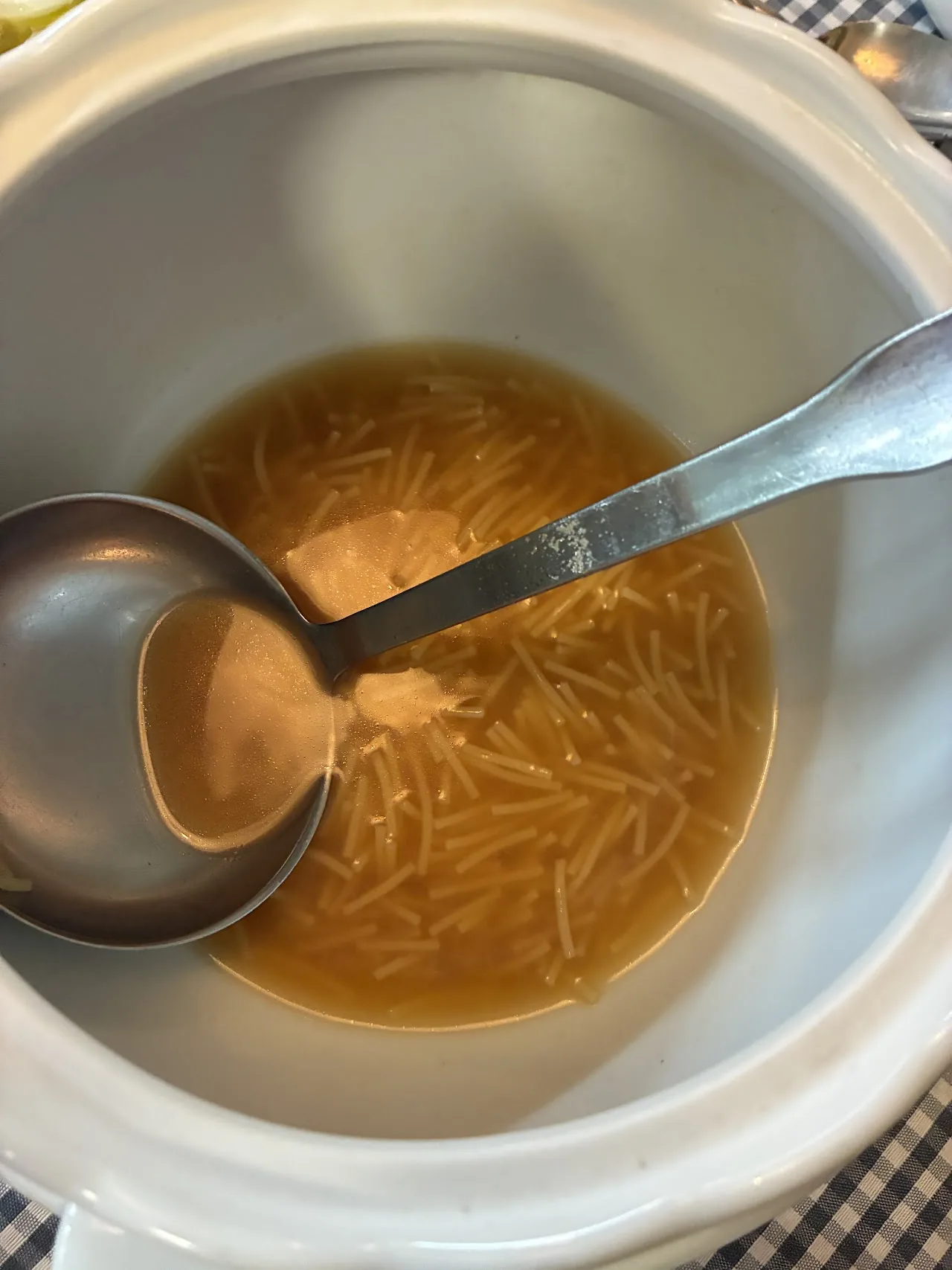 A bowl of noodle soup with a spoon