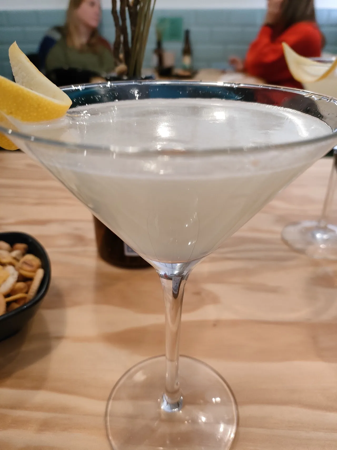 A martini cocktail garnished with a lemon twist