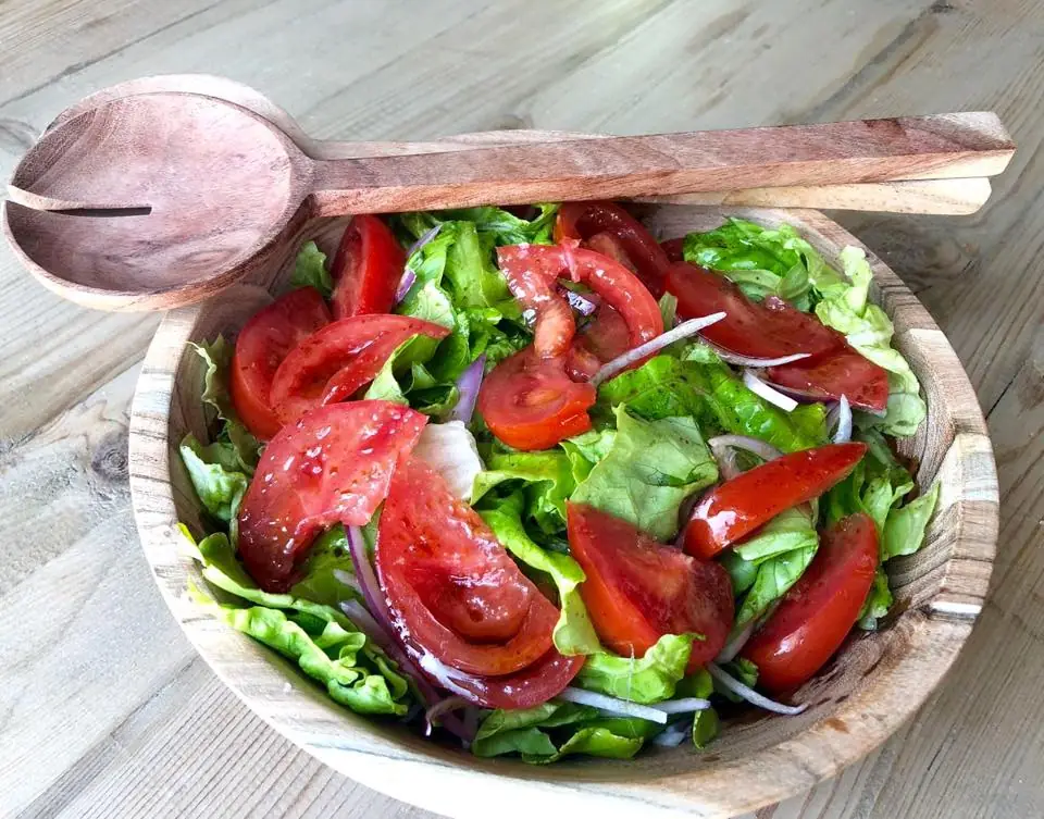 Tomato, lettuce and red onion salad in a wooden bowl