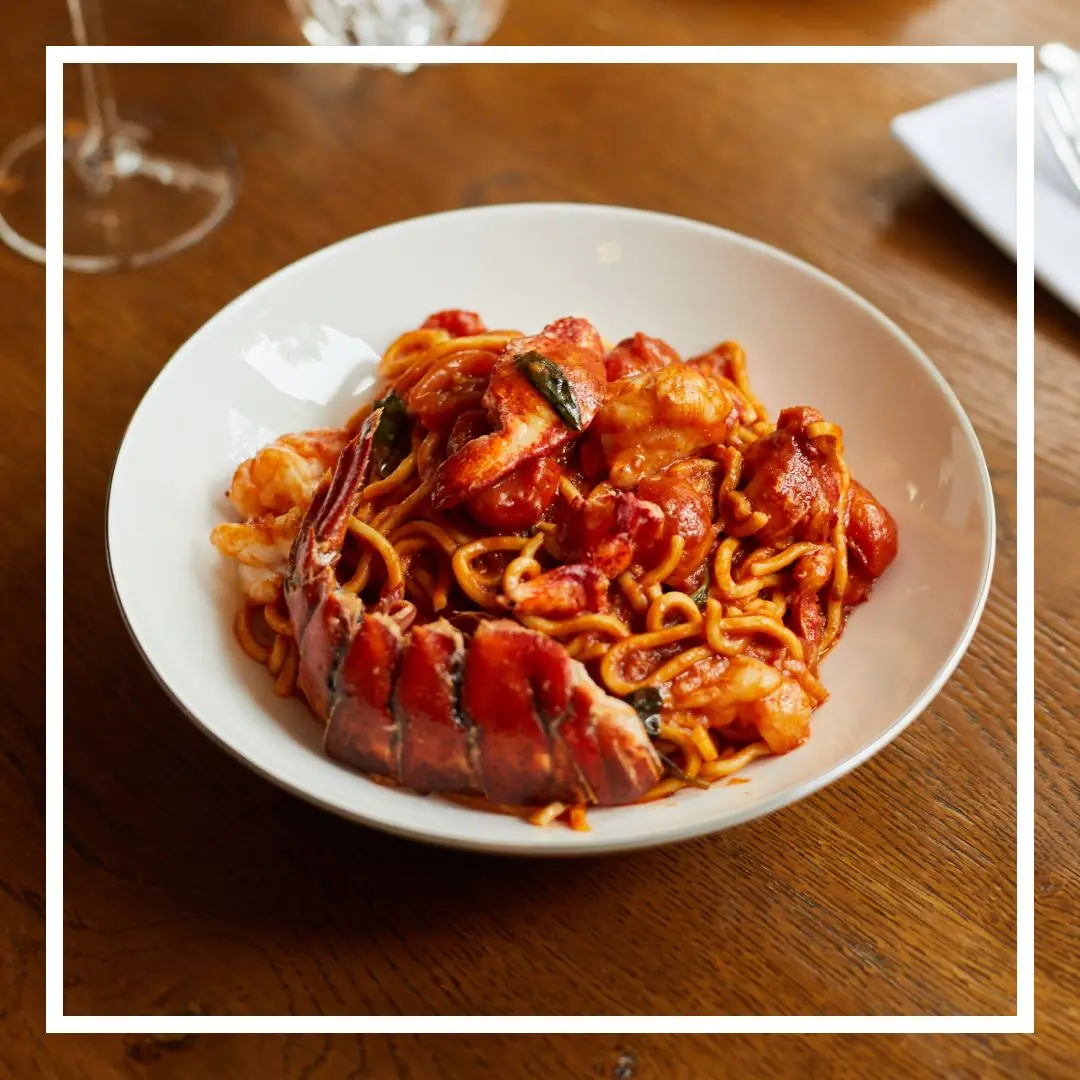 Lobster and shrimp spaghetti in a red sauce, with sliced lobster tail on top, at La Dama