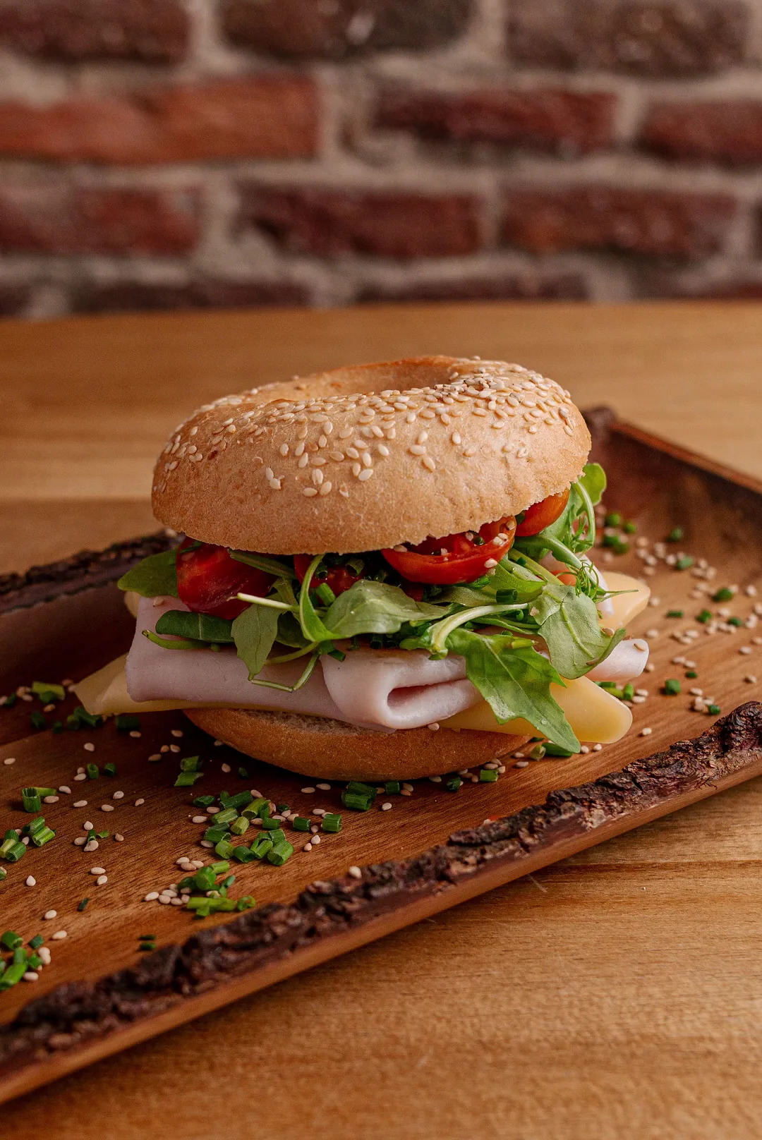 A ham and greens sandwich on a wooden board